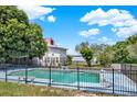 Enclosed pool with clear water next to the estate, with a lake view, surrounded by lush greenery at 9023 Silver Lake Dr, Leesburg, FL 34788