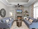 Inviting living room featuring a stone fireplace, hardwood floors, and a ceiling fan at 9518 Mid Summer Ln, Leesburg, FL 34788