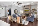 Comfortable living room with stone fireplace, hardwood floors and ceiling fans at 9518 Mid Summer Ln, Leesburg, FL 34788