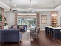 An open living room with hardwood floors, light gray walls, and view to outdoor space at 9518 Mid Summer Ln, Leesburg, FL 34788