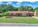 Well-maintained single-story home with a brick facade and mature trees at 1007 N Shore Dr, Leesburg, FL 34748