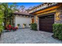 Elegant exterior showcasing lush landscaping and a charming outdoor seating area near the stone-accented garage at 10122 Royal Island Ct, Orlando, FL 32836