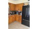 Cozy kitchen features wood cabinets, tile floors, and a stainless steel refrigerator at 1022 E 3Rd Ave, Mount Dora, FL 32757