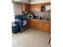 A functional kitchen offers tile flooring, wooden cabinets, and modern appliances at 1022 E 3Rd Ave, Mount Dora, FL 32757