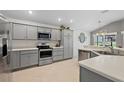 Modern kitchen boasts stainless steel appliances and sleek gray cabinetry at 11287 Stewart Loop, Oxford, FL 34484