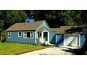 Charming blue home featuring a well-manicured front yard and a one-car garage at 1225 E 1St Ave, Mount Dora, FL 32757