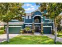 Charming two-story house featuring a lush front yard, mature trees, and a welcoming entrance at 12833 Hyland Ln, Clermont, FL 34711