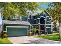 Stunning home featuring a green three-car garage, beautiful blue facade, and manicured lawn at 12833 Hyland Ln, Clermont, FL 34711