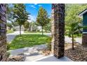 View of a landscaped front yard with mature trees and a glimpse of neighboring homes at 12833 Hyland Ln, Clermont, FL 34711