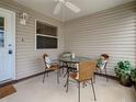 A screened in porch with ceiling fan and a glass table with four cushioned chairs at 1291 Jonesville Ter, The Villages, FL 32162
