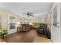 Cozy living room with wood laminate flooring, neutral paint, and a ceiling fan at 1303 E Schwartz Blvd, The Villages, FL 32159