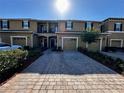 Townhouse exterior with a one-car garage, brick paver driveway, and a private balcony at 147 Aston Grande Dr, Daytona Beach, FL 32124