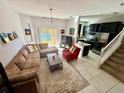 Spacious living room with large windows, comfortable seating, and seamless flow to the modern kitchen at 147 Aston Grande Dr, Daytona Beach, FL 32124