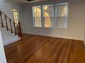 A bright living room featuring hardwood floors and large windows, offering natural light and charm at 148 W 9Th Ave, Mount Dora, FL 32757