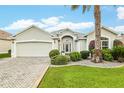 Charming single-story home featuring a lush, landscaped front yard and a convenient two-car garage at 1521 Southport St, The Villages, FL 32162
