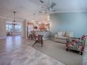 Inviting living room with tile floors, ceiling fan and open to kitchen, creating a spacious and connected living space at 1701 Lakewood Dr, The Villages, FL 32162