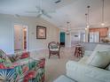 Bright and airy living room featuring tile flooring, a ceiling fan, and comfortable seating, open to other living spaces at 1701 Lakewood Dr, The Villages, FL 32162