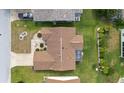 Aerial view of a house with a brown roof, screened in porch, and well-maintained lawn at 17068 Se 96Th Chapelwood Cir, The Villages, FL 32162