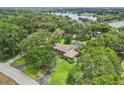 Aerial view of an estate home surrounded by lush landscaping with a private pool near a lake at 1930 Country Club Rd, Eustis, FL 32726