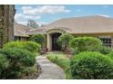 Charming front entrance with stone accents, a covered porch, and manicured landscaping enhancing curb appeal at 1930 Country Club Rd, Eustis, FL 32726