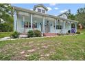 Charming single story home boasts a light blue exterior, dormer windows, and a spacious front porch at 19703 Lake Lincoln Ln, Eustis, FL 32736