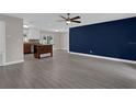 Open living room featuring wood flooring, ceiling fan, natural lighting and neutral paint at 209 Edgewood Dr, Clermont, FL 34711