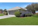 The exterior angle shows the spacious side entry garage and manicured lawn at 21926 King Alfred St, Leesburg, FL 34748