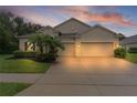 Inviting home featuring a two-car garage, manicured landscaping, and a welcoming entrance at 2424 Plumadore Dr, Grand Island, FL 32735