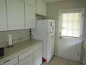 Bright kitchen with white cabinets, a refrigerator and access to the backyard at 2501 Sheridan Rd, Mount Dora, FL 32757