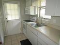 Functional kitchen with white cabinetry, appliances, and a stainless steel sink at 2501 Sheridan Rd, Mount Dora, FL 32757