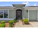 Charming home featuring a front door with glass, neutral paint, and a two car garage at 2568 Jupiter Way, The Villages, FL 32163