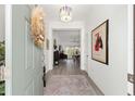 Inviting entryway featuring a decorative rug, stylish lighting, and a view into the open-concept living area at 2988 Sentell St, The Villages, FL 32163