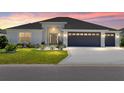 Charming home at sunset featuring a well-manicured lawn, a two-car garage, and decorative front door with a wreath at 2988 Sentell St, The Villages, FL 32163