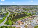 Aerial view shows a well-maintained community with homes surrounding scenic ponds and winding roads at 2998 Kramer Ct, The Villages, FL 32163