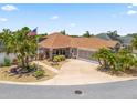 Well-manicured home boasts a spacious driveway, lush plantings, and a welcoming facade at 2998 Kramer Ct, The Villages, FL 32163