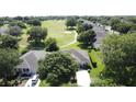 Wide aerial view of a neighborhood, featuring homes nestled amidst trees and green fairways at 3559 Chapel Hill Blvd, Clermont, FL 34711