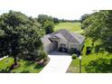 Overhead view of a home with a well-kept lawn, set against the backdrop of a lush golf course at 3559 Chapel Hill Blvd, Clermont, FL 34711