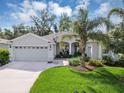 Charming single-story home featuring a manicured lawn, a two-car garage, and a welcoming front porch at 4581 Shenandoah River Trl, Leesburg, FL 34748