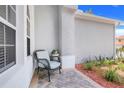 Cozy front porch area with a wicker chair, tiled floor, and decorative plants at 4716 Block Island Ln, Clermont, FL 34714