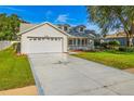 Charming single-Gathering home with manicured lawn, two-car garage and driveway starburst detail at 508 Woodview Dr, Tavares, FL 32778