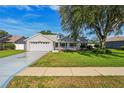Charming single-Gathering home features a well-manicured lawn, two-car garage, and welcoming front porch at 508 Woodview Dr, Tavares, FL 32778