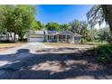 A charming single-story home featuring a screened front porch, garage, and a driveway with ample parking at 513 Barwick St, Wildwood, FL 34785