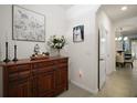Inviting foyer featuring elegant console table, decor and tile flooring at 5333 Loblolly Ln, Wildwood, FL 34785