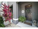 Welcoming entryway with decorative plants and a stylish 'Welcome' sign on the front door at 5333 Loblolly Ln, Wildwood, FL 34785