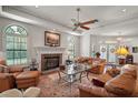 Expansive living room with fireplace, ceiling fan, and plentiful seating, offering a warm and inviting atmosphere at 621 High Point Dr, Mount Dora, FL 32757