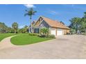 Beautiful single Gathering home with a 3-car garage and lush green lawn at 7629 Lake Angelina Dr, Mount Dora, FL 32757