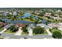 Aerial view of a community highlighting the lake and several homes, showcasing a serene neighborhood at 7873 Crosswinds Way, Mount Dora, FL 32757