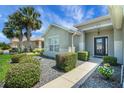 Inviting front exterior with lush landscaping, decorative shrubbery, and a welcoming entrance at 8652 Se 133Rd Ln, Summerfield, FL 34491