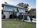 Spacious backyard featuring a modern hot tub, lush green grass, and mature trees for added privacy at 101 S Dixie Ave, Fruitland Park, FL 34731