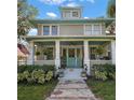 Beautiful two-story home with a covered porch, white columns, blue accents, and a well-manicured front yard at 101 S Dixie Ave, Fruitland Park, FL 34731